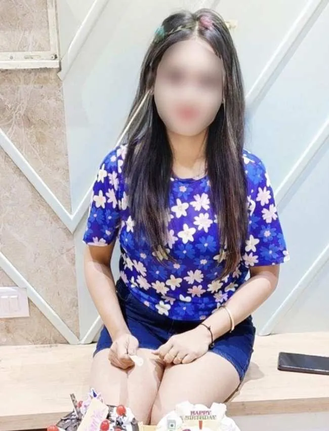 Pune call girl Faria sitting on chair and cut cake