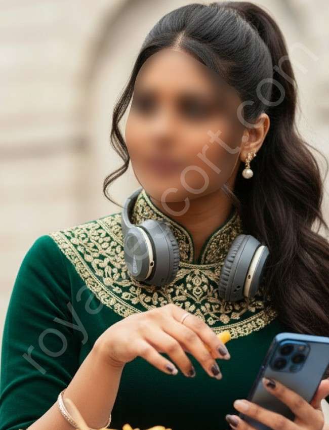 Independent Escort & Call Girl Harshika wearing green abroidy dress and phone in her hand