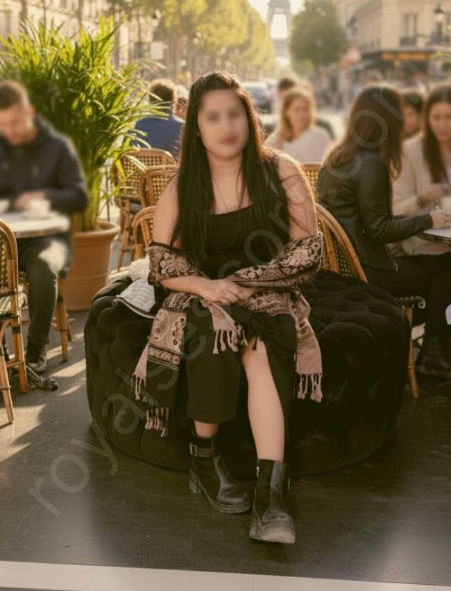 VIP Escort Ruqaiya sitting on open restaurent and wearing black gown