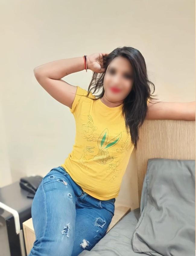 Independent Escort Zivah sitting on sofa wearning jeans and top